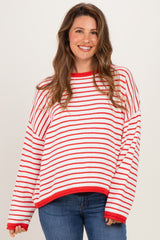 woman wearing a red and white striped oversized maternity sweater with long sleeves