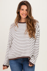woman wearing a striped maternity sweater in white and brown with a relaxed fit and long sleeves
