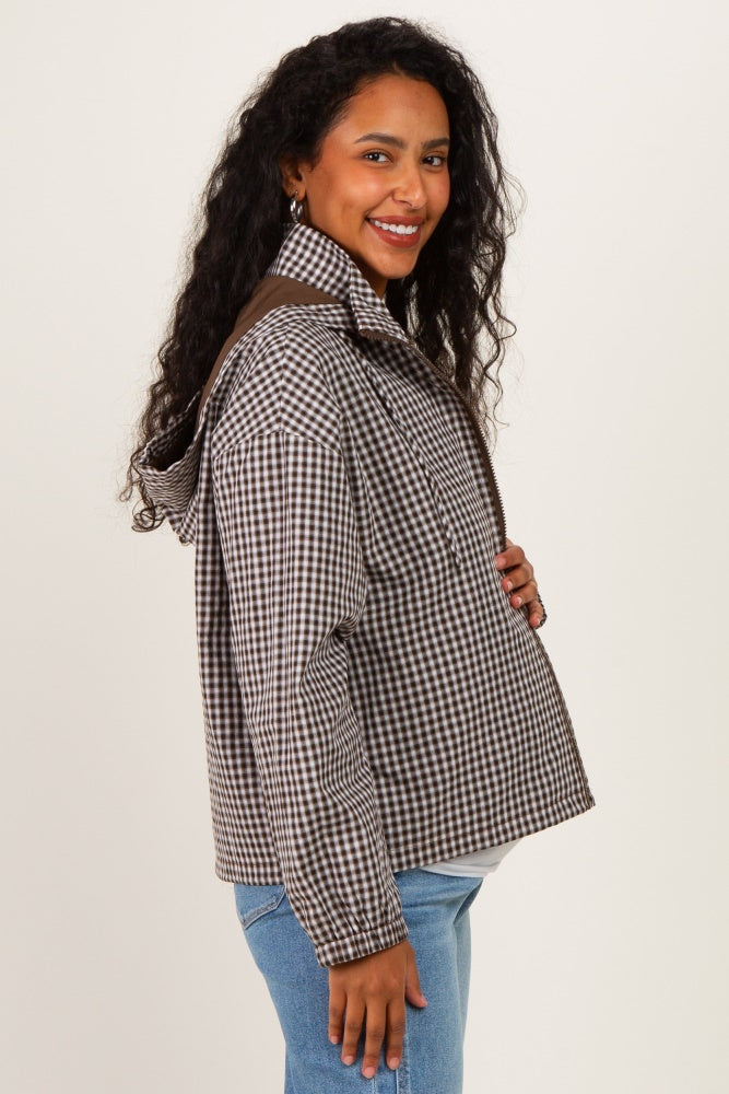 woman wearing a brown and white checked maternity jacket and showing her baby bump