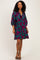 woman wearing a teal floral print dress with short sleeves and a relaxed fit, standing in a pose