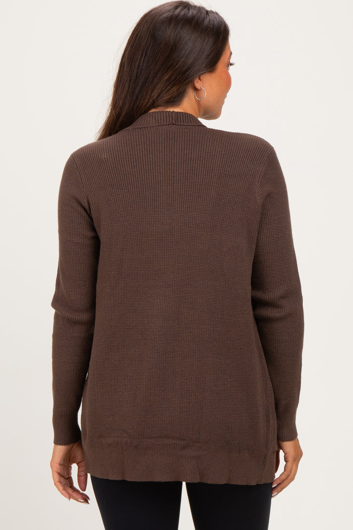 woman wearing a brown ribbed maternity cardigan, styled with a relaxed fit