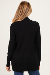 woman wearing a black maternity sweater with a relaxed fit, view from the back, showcasing a longer length
