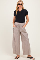 woman wearing a black short sleeve maternity top and relaxed striped maternity pants with pockets