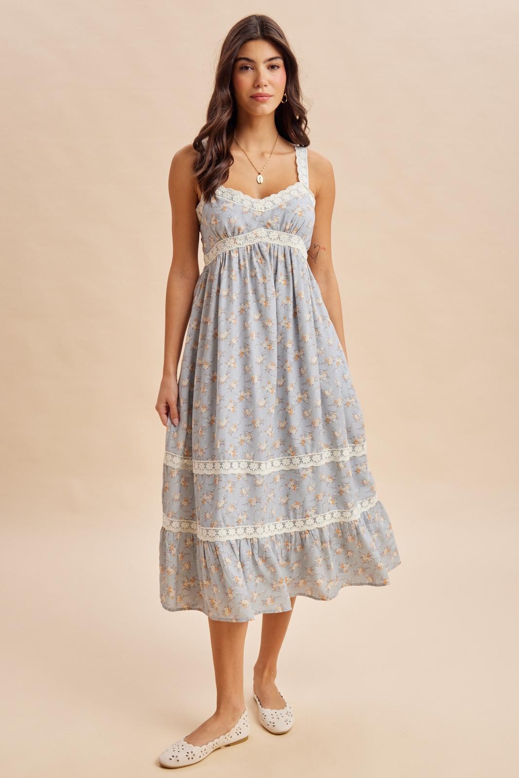 woman wearing a light blue floral maxi dress with lace detailing and spaghetti straps