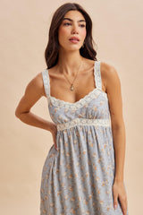 woman wearing a light blue floral print dress with lace trim and adjustable straps