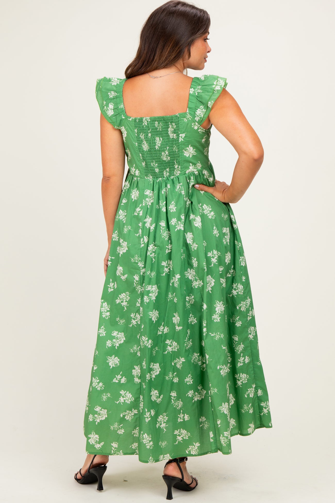 woman wearing a green floral maternity maxi dress with ruffled sleeves and a smocked back