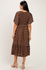 woman wearing a brown polka dot midi dress with puff sleeves and a ruffled hem, viewed from the back