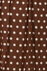 brown polka dot fabric with large white dots in a flowing style