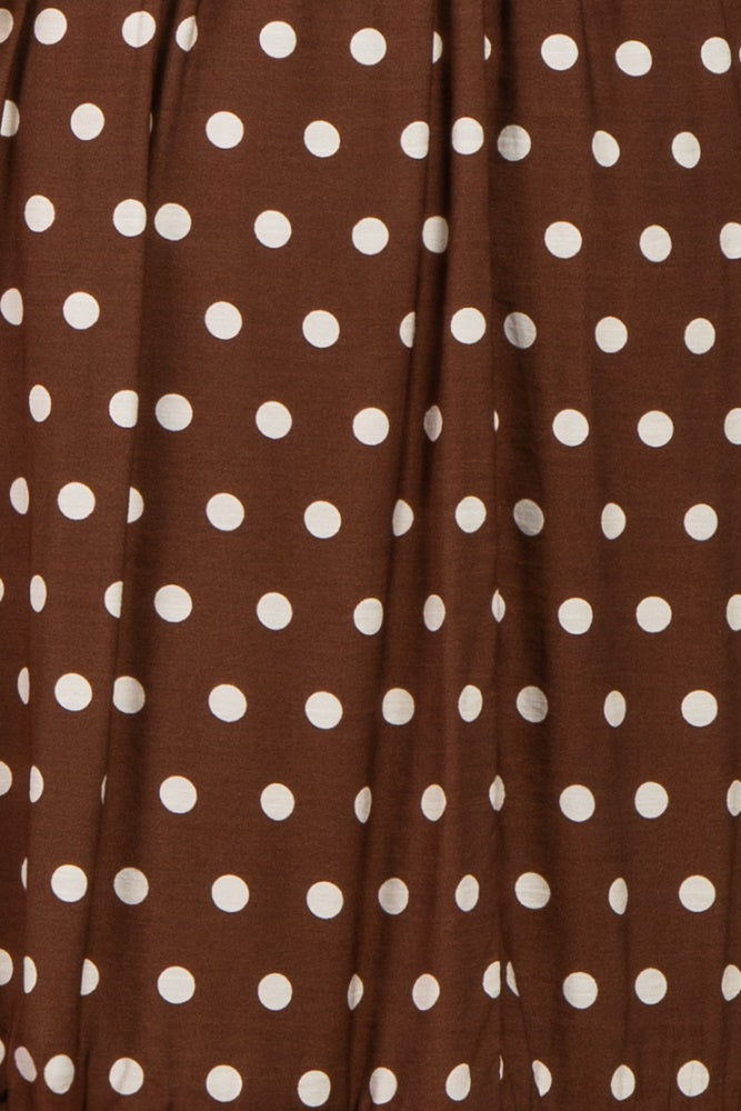 brown polka dot fabric with large white dots in a flowing style