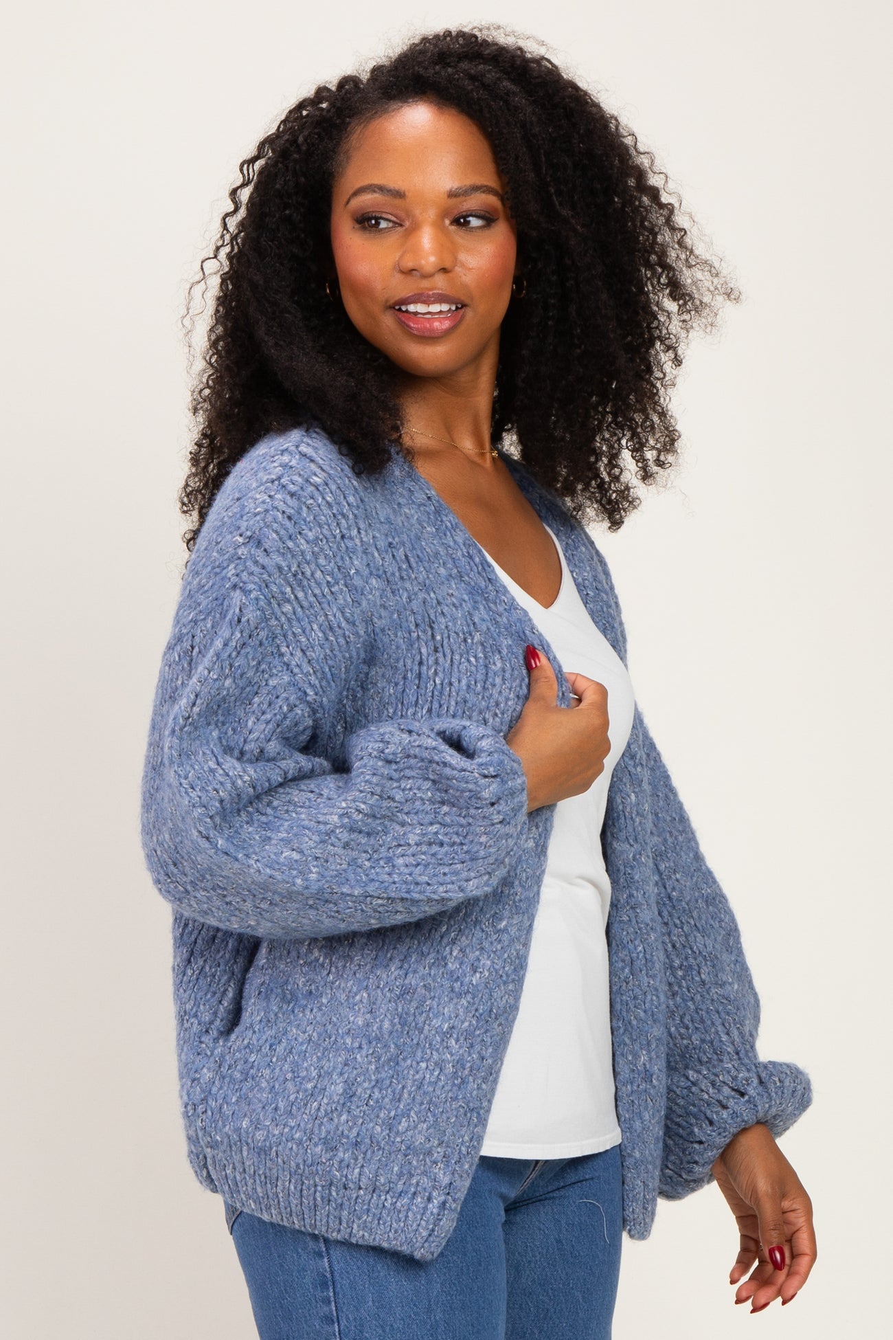 woman wearing a cozy blue oversized cardigan over a white top, styled with casual denim jeans