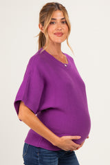 woman wearing a purple short sleeve maternity sweater and holding her baby bump