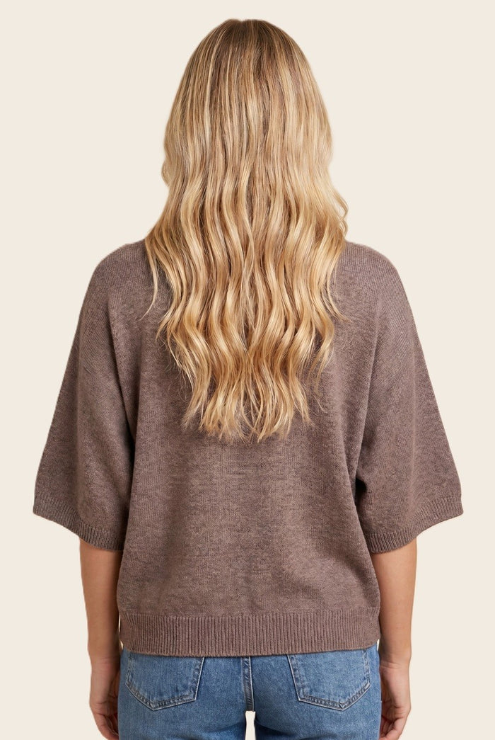 woman wearing a brown oversized sweater with short sleeves, seen from the back