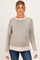 woman wearing a light gray striped maternity sweater with a neutral hem and cuffs, showing her baby bump
