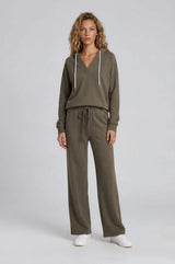 woman wearing a relaxed olive green hoodie and matching wide-leg pants with a drawstring waist