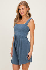 woman wearing a blue and white striped smocked sundress with wide straps and a flared skirt