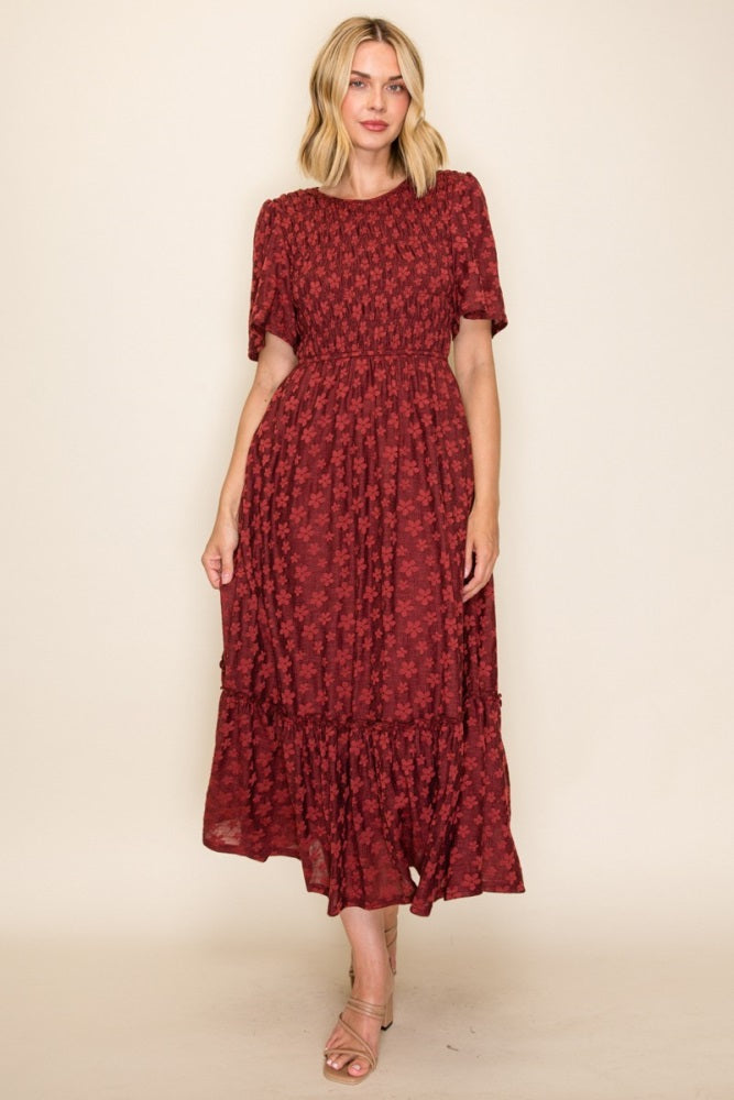 woman wearing a burgundy floral midi dress with short sleeves and a tiered ruffle hem