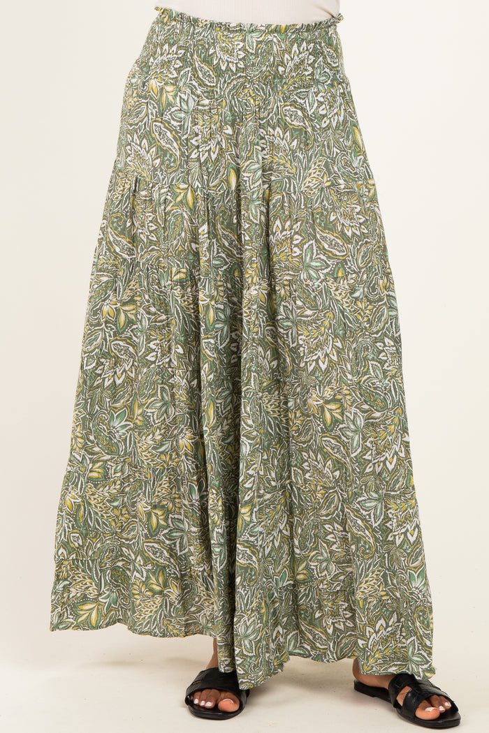 woman wearing a green floral patterned maxi skirt with an elastic waistband and flowing silhouette
