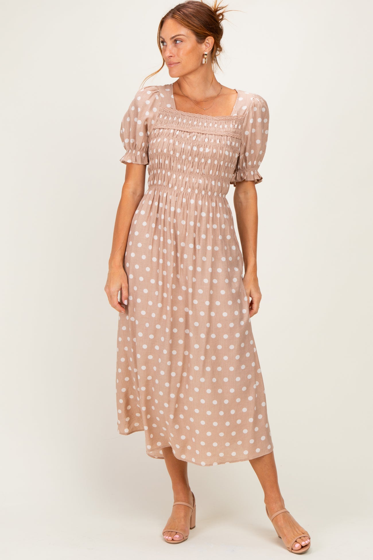 woman wearing a brown polka dot midi dress with puff sleeves and a smocked bodice