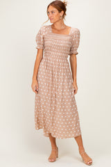 woman wearing a brown polka dot midi dress with puff sleeves and a smocked bodice