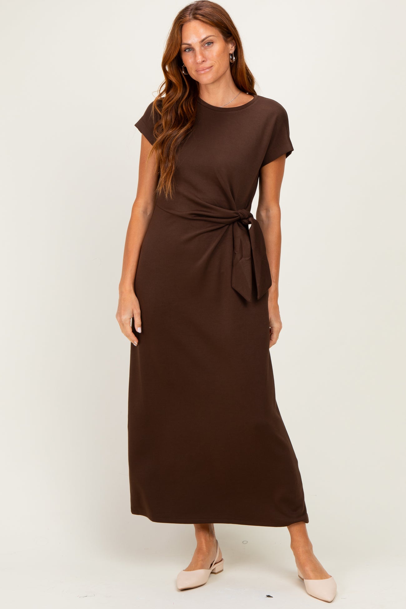 woman wearing a brown short sleeve maxi dress with a side tie detail