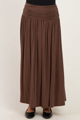 woman wearing a brown maxi skirt with a gathered waistband and flowing silhouette