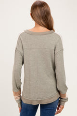 woman wearing a green long sleeve maternity top with stripes on the sleeves, viewed from the back