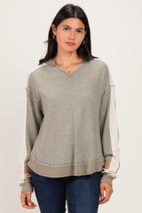 woman wearing a green and beige color-blocked long sleeve hoodie with a loose fit and v-neckline