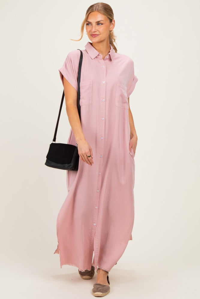 woman wearing a pink button-up maxi shirt dress with short sleeves and two front pockets, carrying a black bag