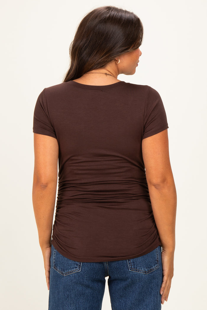 woman wearing a brown short sleeve maternity top with ruching detailing on the back