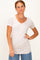 woman wearing a light beige short sleeve v-neck top paired with high-waisted denim jeans