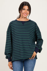 woman wearing a green and navy striped oversized sweatshirt with long sleeves and a relaxed fit