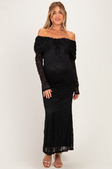 woman wearing a black off-the-shoulder lace maternity dress with long sleeves and a fitted silhouette, showing her baby bump