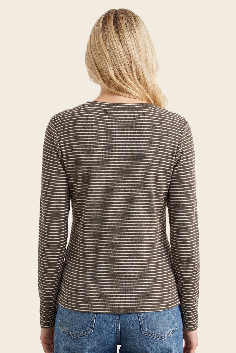 woman wearing a brown and white striped long sleeve top, viewed from the back, paired with blue jeans