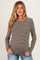 woman wearing a brown and cream striped maternity top with long sleeves and a relaxed fit, showing her baby bump