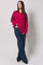 woman wearing a fuchsia oversized cardigan with button details and wide-leg jeans