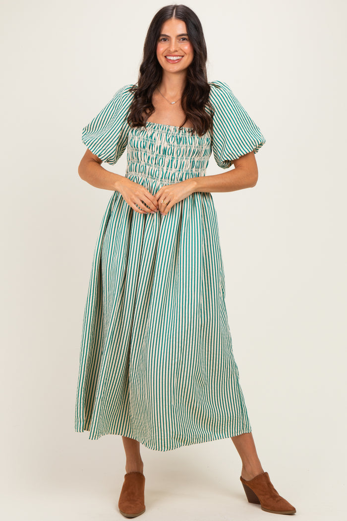 woman wearing a green and white striped off-the-shoulder maxi dress with puff sleeves and a smocked bodice