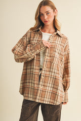 woman wearing a brown plaid oversized button-up shirt with buttons and a relaxed fit