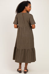 woman wearing a brown and black plaid midi dress with short sleeves and a ruffled hem, shown from the back