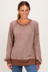 woman wearing a brown striped long sleeve pullover sweatshirt with a relaxed fit and crew neckline
