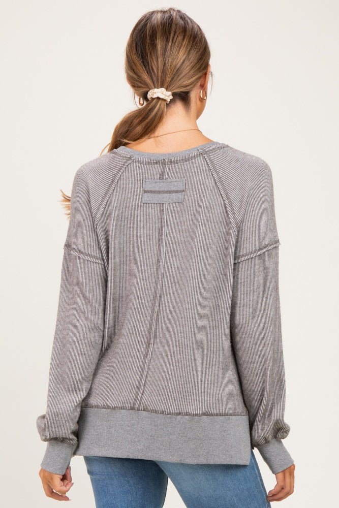 woman wearing a gray striped long sleeve maternity top, showing the back view with ribbed details