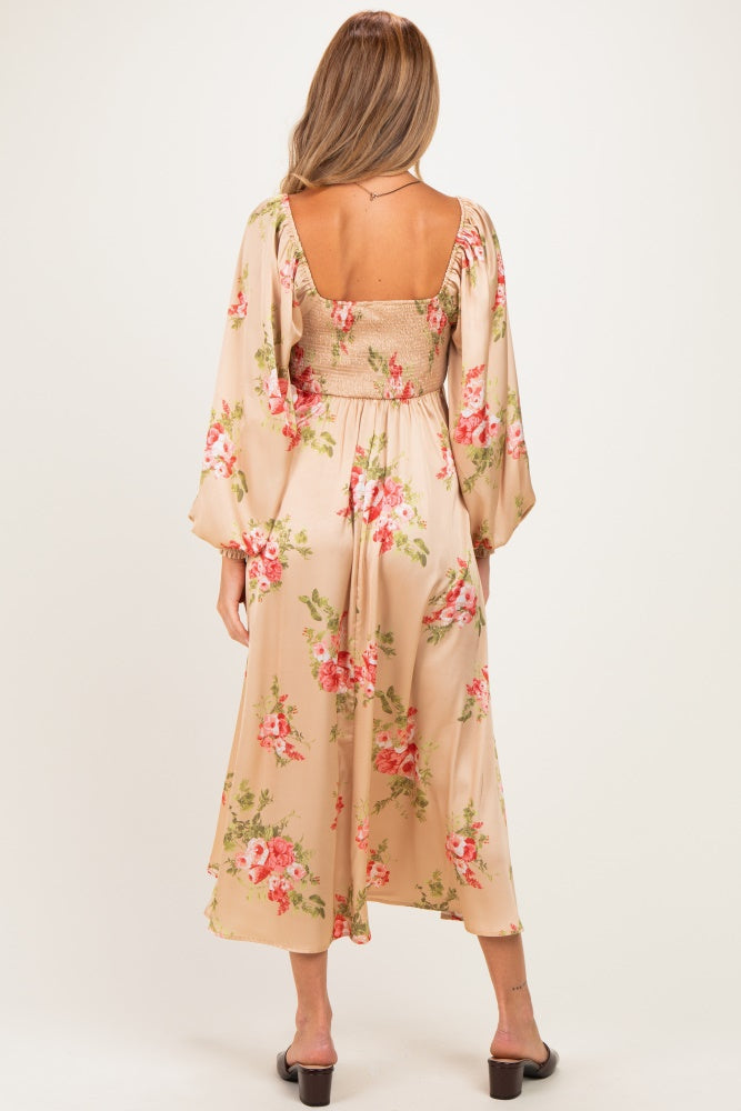 woman wearing a floral maternity dress with bell sleeves and a fitted bodice, showing off a baby bump from the back