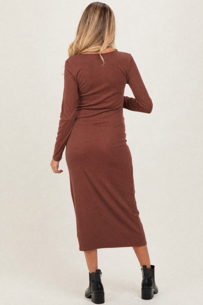 woman wearing a brown long sleeve maternity dress, showing a fitted style and mid-calf length from the back.