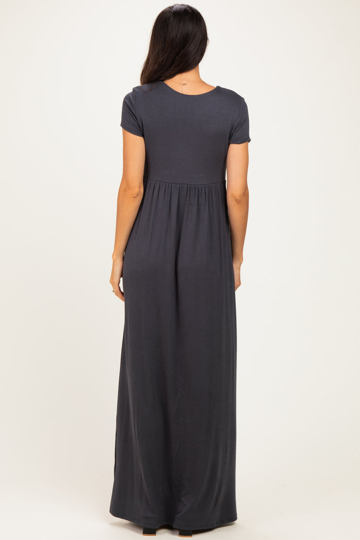 woman wearing a dark gray short sleeve maxi dress with a gathered waist and flowy skirt