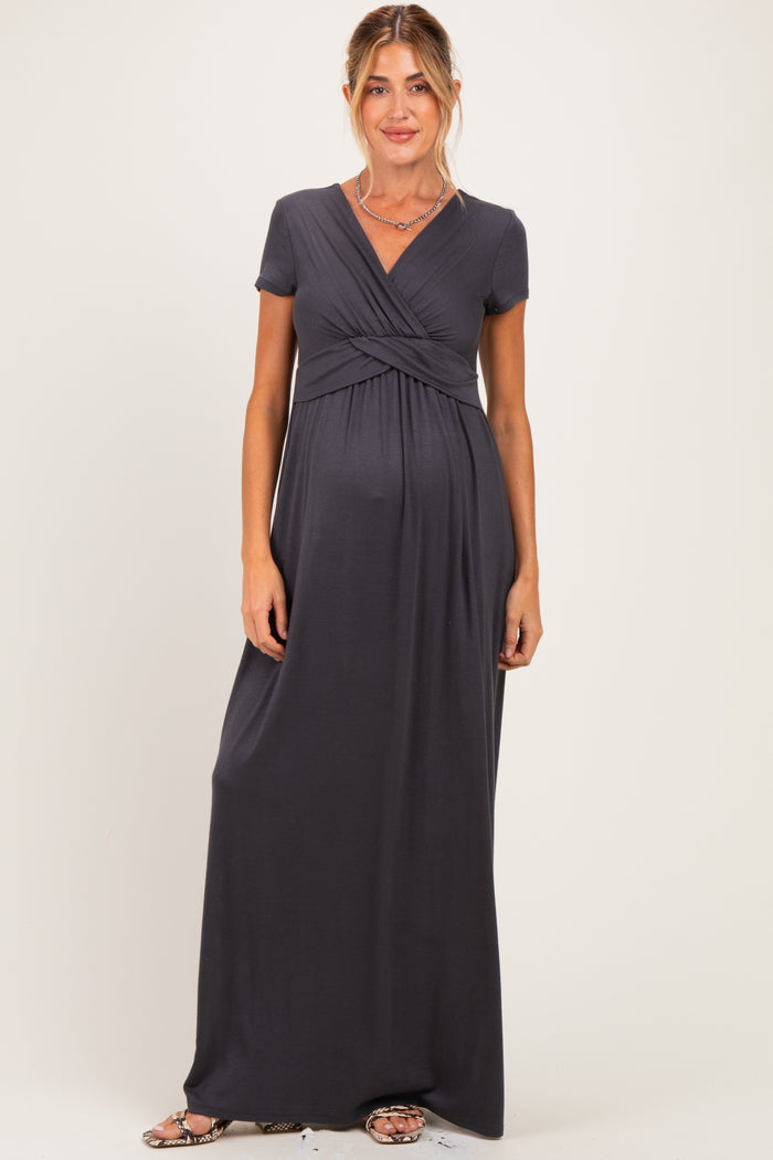 woman wearing a dark gray short sleeve maternity maxi dress with a cross-over front and baby bump visible