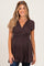 woman wearing a dark brown maternity top with a wrap style and short sleeves, showcasing her baby bump
