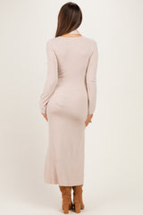 woman wearing a long sleeve ribbed blush pink maternity dress, back view