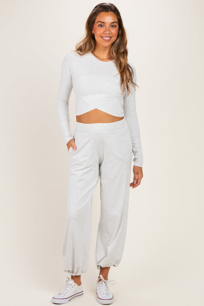 woman wearing a light gray long sleeve cropped maternity top and matching relaxed-fit maternity joggers