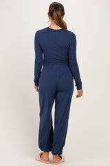 woman wearing a dark blue long sleeve maternity top and matching pants, showing a relaxed fit from the back