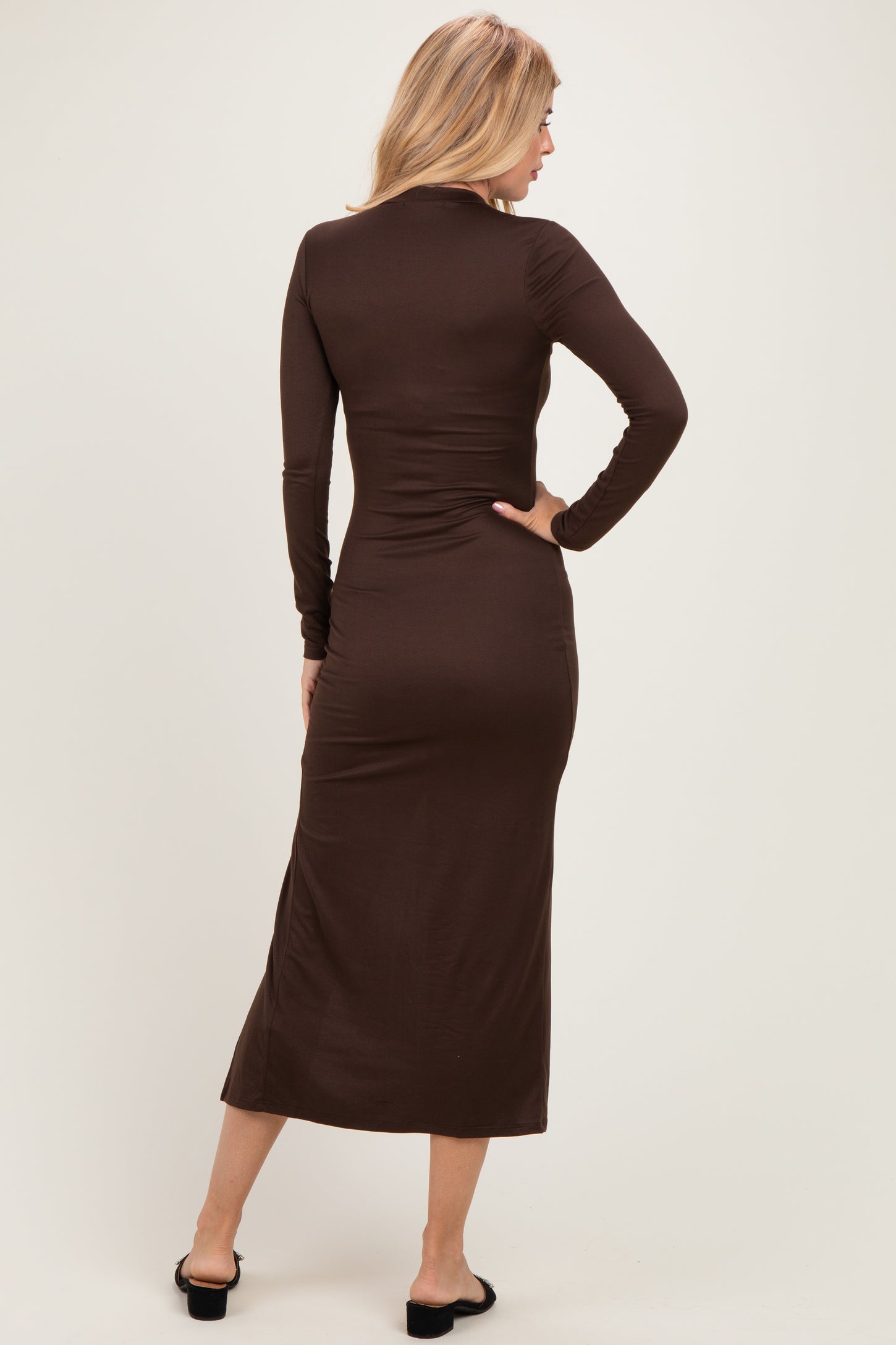 woman wearing a form-fitting brown long sleeve midi dress, shown from the back