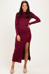woman wearing a burgundy long sleeve midi dress with a side slit and a relaxed fit